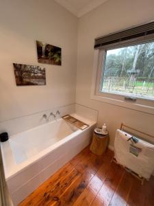 una bañera en un baño con ventana en Treetops at Harrietville, en Harrietville