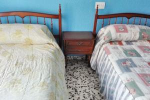 two beds sitting next to each other in a bedroom at Spacious apartment with balcony - Guardamar del Segura - 100 m² in Guardamar del Segura