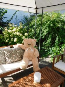 a teddy bear sitting on a porch swing at Das Bärenhaus in Bergen