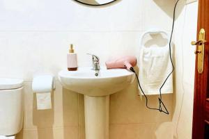 a bathroom with a sink and a toilet and a mirror at Welcoming House with Sea View in Corme-Porto in Corme-Puerto +22 photos