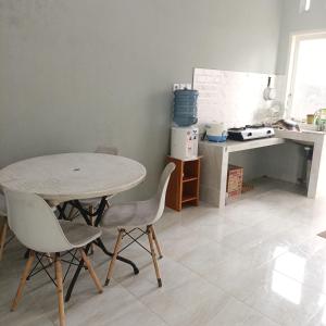 a kitchen with a table and two chairs and a counter at Urban Homestay Syariah in Bukittinggi