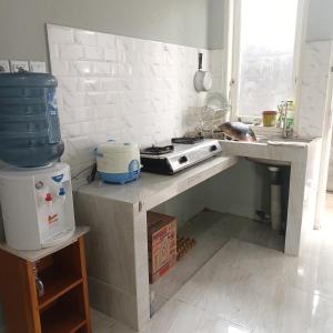 a kitchen with a counter with a sink and a stove at Urban Homestay Syariah in Bukittinggi