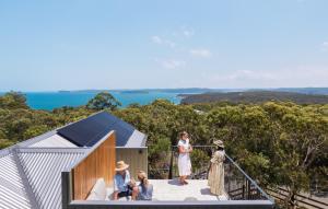 克里卡尔Bells at Killcare Boutique Hotel, Restaurant & Spa的一群人站在房子的阳台上