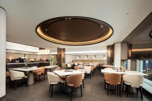 un ristorante con tavoli e sedie e un grande soffitto di Atour Hotel Hangzhou Wulin Square Shentang Bridge a Hangzhou