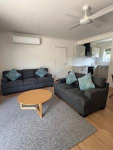 a living room with two couches and a coffee table at Willow Dene Holiday Apartments in Bright +41 photos