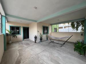 a hammock in a room with plants and windows at Casa Arboledas in Manzanillo