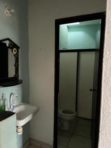 a bathroom with a sink and a toilet at Casa Arboledas in Manzanillo