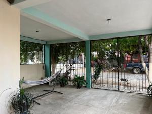 a screened in porch with a hammock and a fence at Casa Arboledas in Manzanillo +2 photos