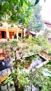 a garden with a pond in front of a building at Lee Homestay in Hanoi