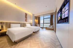 Ένα ή περισσότερα κρεβάτια σε δωμάτιο στο Atour S Hotel Wuhan Garden Expo