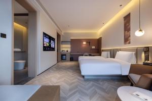 Ένα ή περισσότερα κρεβάτια σε δωμάτιο στο Atour S Hotel Wuhan Garden Expo