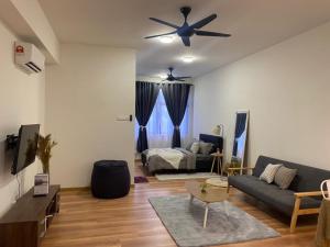 マラッカにあるThe Quartz Residence - City Centre Condoのソファと天井ファンのあるリビングルーム