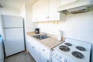 une cuisine avec un évier et un réfrigérateur blanc dans l'établissement Waikiki Seaside Monarch Paradise Hotel Studio Near Waikiki - Mountain and City View - Full Kitchen, à Honolulu