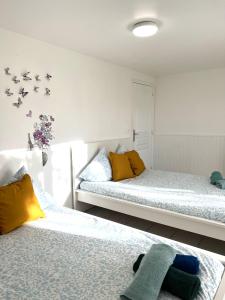 1 Schlafzimmer mit 2 Betten und gelben Kissen in der Unterkunft Rosny Sous Bois centre ville charmant appartement in Rosny-sous-Bois
