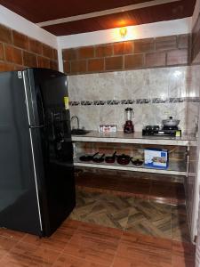 a black refrigerator in a kitchen with a counter at Sol Apartamento Santa Elena in Santa Helena