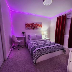 a purple bedroom with a bed and a chair at Ivory Staycation Suite with Free Street Parking, Shared kitchen and washroom in London +9 photos