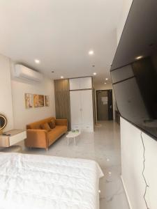 ein Wohnzimmer mit Sofa und Fernseher in der Unterkunft Glory Heights - Vinhomes Grank Park in Long Bình