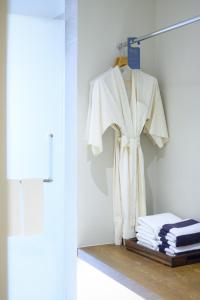 ein weißer Bademantel hängt auf einem Kleiderständer in einem Zimmer in der Unterkunft Arinara Beach Resort Phuket - SHA Extra Plus in Strand Bang Tao