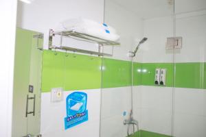 a shower in a bathroom with green and white walls at 7Days Premuim Suqian Xiangwang Home Village Scenic Spot in Suqian