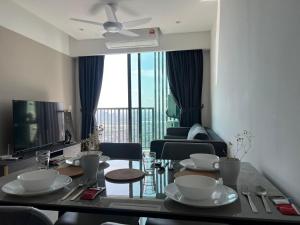 a living room with a dining room table with dishes on it at Edumetro B32 3 Bedroom Subang Sunway By MICASA GROUP in Subang Jaya
