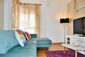 salon z zieloną kanapą i oknem w obiekcie Modern Apartment Málaga 80 m² + Balcony w Maladze
