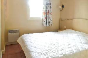 a bedroom with a white bed and a window at Appartement lumineux Roquebrune 45m² avec piscine partagée in Roquebrune-sur-Argens