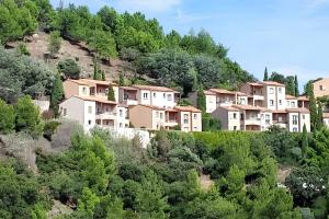 a group of houses on the side of a hill at Appartement lumineux Roquebrune 45m² avec piscine partagée in Roquebrune-sur-Argens