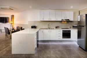 a kitchen with white cabinets and a counter top at Nautilos On The Harbour in Newcastle