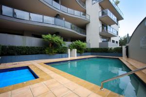 a swimming pool in front of a building at Nautilos On The Harbour in Newcastle