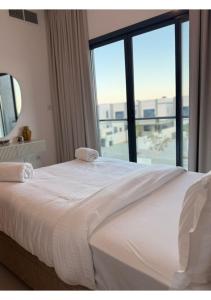a bedroom with a white bed with a large window at 1 - BLUE WORLD - Al Dana Villas in Fujairah