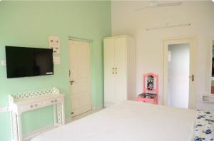 Un dormitorio con una cama y un televisor en la pared. en Casa Oceanara 2Room studio & lounge terrace, en Panaji