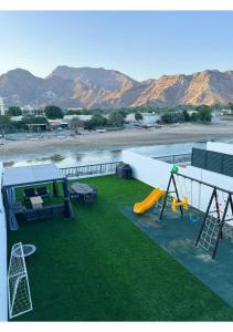 a backyard with a playground with a play area and a swing at 1 - BLUE WORLD - Al Dana Villas in Fujairah