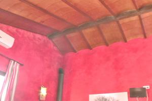 a room with a red wall and a ceiling at Charming House in Estepa with Shared Pool in Lora de Estepa