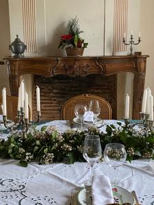 a table with a white table cloth with candles and flowers at Manoir BLANCHE HAUT Chambres et tables d hôtes in Villeneuve-sur-Lot