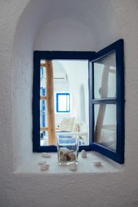 a window with a glass vase with rocks in it at Blu Bianco Cave House by SV in Oia