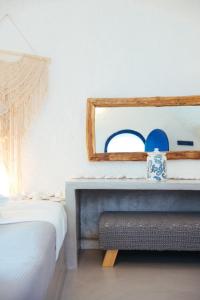 a bedroom with a mirror and a bed at Blu Bianco Cave House by SV in Oia