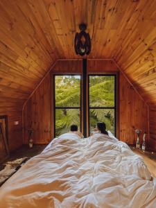 Ein Mann und eine Frau, die in einem Bett im Schlafzimmer liegen in der Unterkunft Cabana aconchegante em meio à natureza in Morro Reuter + 40 Fotos