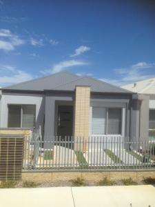 a house with a white fence in front of it at Eden Beach Holiday Getaway in Jindalee