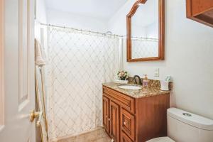 Un baño con inodoro, lavabo y espejo. en Peaceful Oasis, en Anaheim 15 fotos más