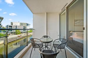 金斯顿Stylish 1-Bed Retreat Steps from Foreshore的阳台配有桌椅和1张床。