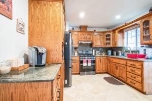Una cocina con gabinetes de madera y un refrigerador negro. en Peaceful Oasis, en Anaheim