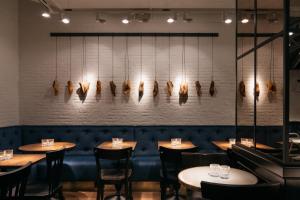 una fila di tavoli in un ristorante con luci sul muro di Ruby Coco Hotel Dusseldorf a Dusseldorf