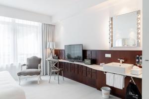 una camera d'albergo con lavandino e specchio di Ruby Coco Hotel Dusseldorf a Dusseldorf