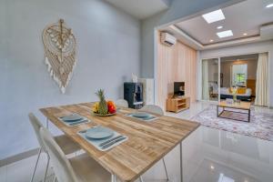 a dining room with a wooden table and chairs at Petite 2bd Fully Equipped Home in Canggu in Kerobokan