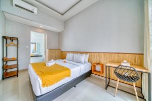a bedroom with a bed and a desk with a chair at Petite 2bd Fully Equipped Home in Canggu in Kerobokan