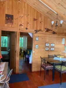 a room with a wooden wall with a table and chairs at Cabaña Mawinda in Pucón