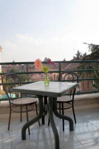 una mesa con sillas y un jarrón con flores en el balcón en Hotel Antico Acquedotto, en Roma