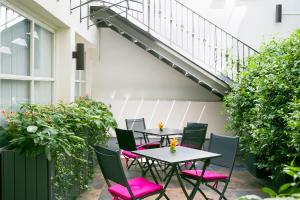 a patio with tables and chairs and plants at Hôtel Le Bellechasse Saint-Germain in Paris
