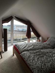 a bedroom with a bed and a large window at City Marina 78 in Cuxhaven