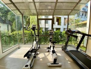 a gym with three tread machines in a room with windows at Apartment in Aonang - great location with pool in Ao Nang Beach